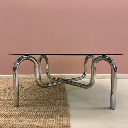 Curved tubular chrome coffee table with round glass top