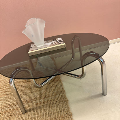 Curved tubular chrome coffee table with round glass top